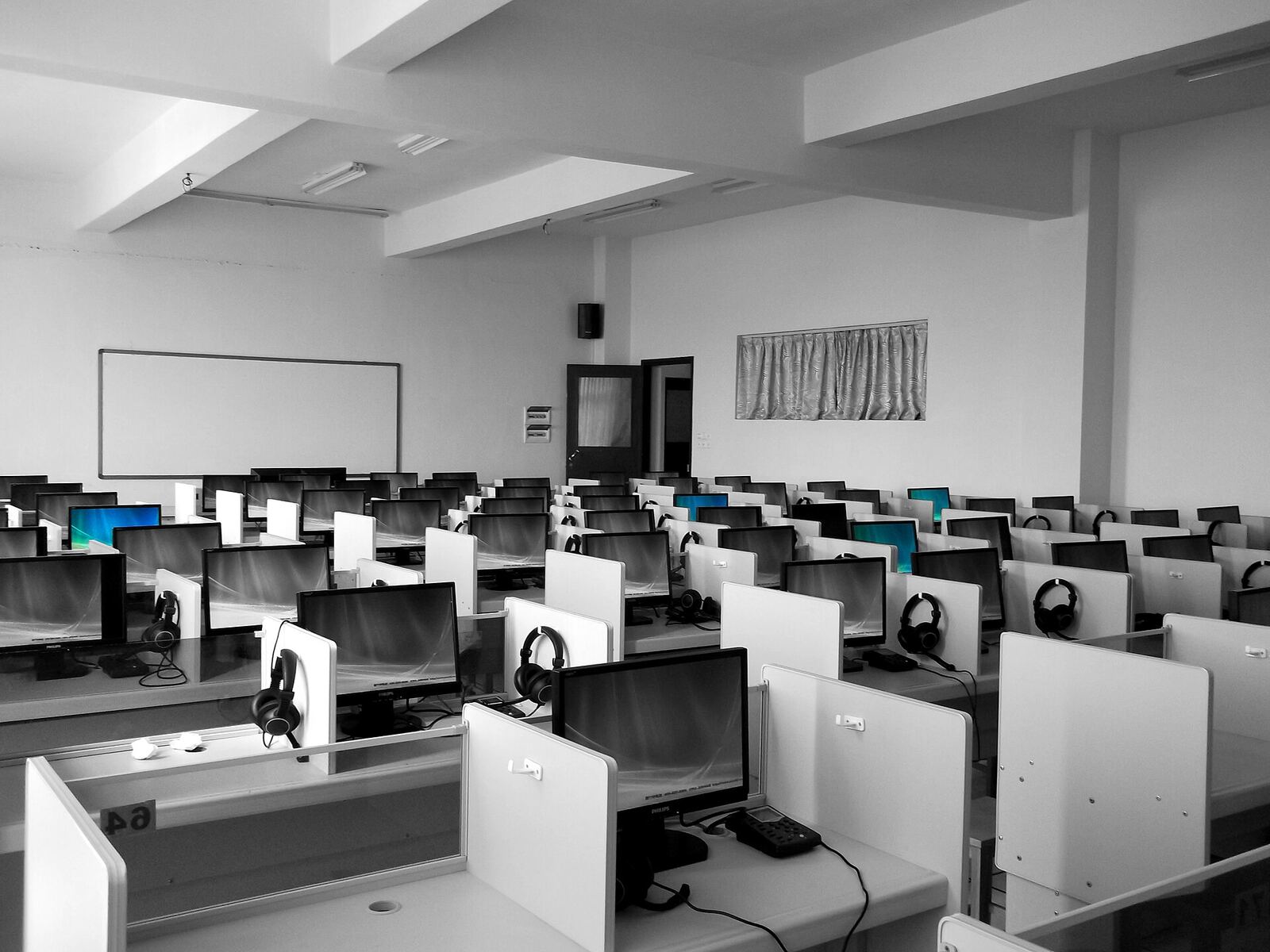 A computer lab with workstations and headsets supports online english lessons.